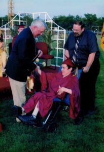 Robert in his cap and gown receiving his diploma. 