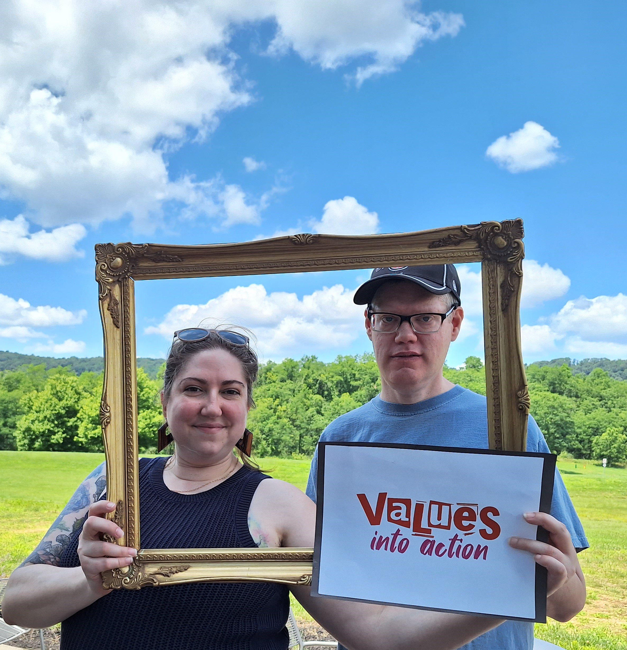 Annie and Michael hold a picture frame with the Values Into Action logo