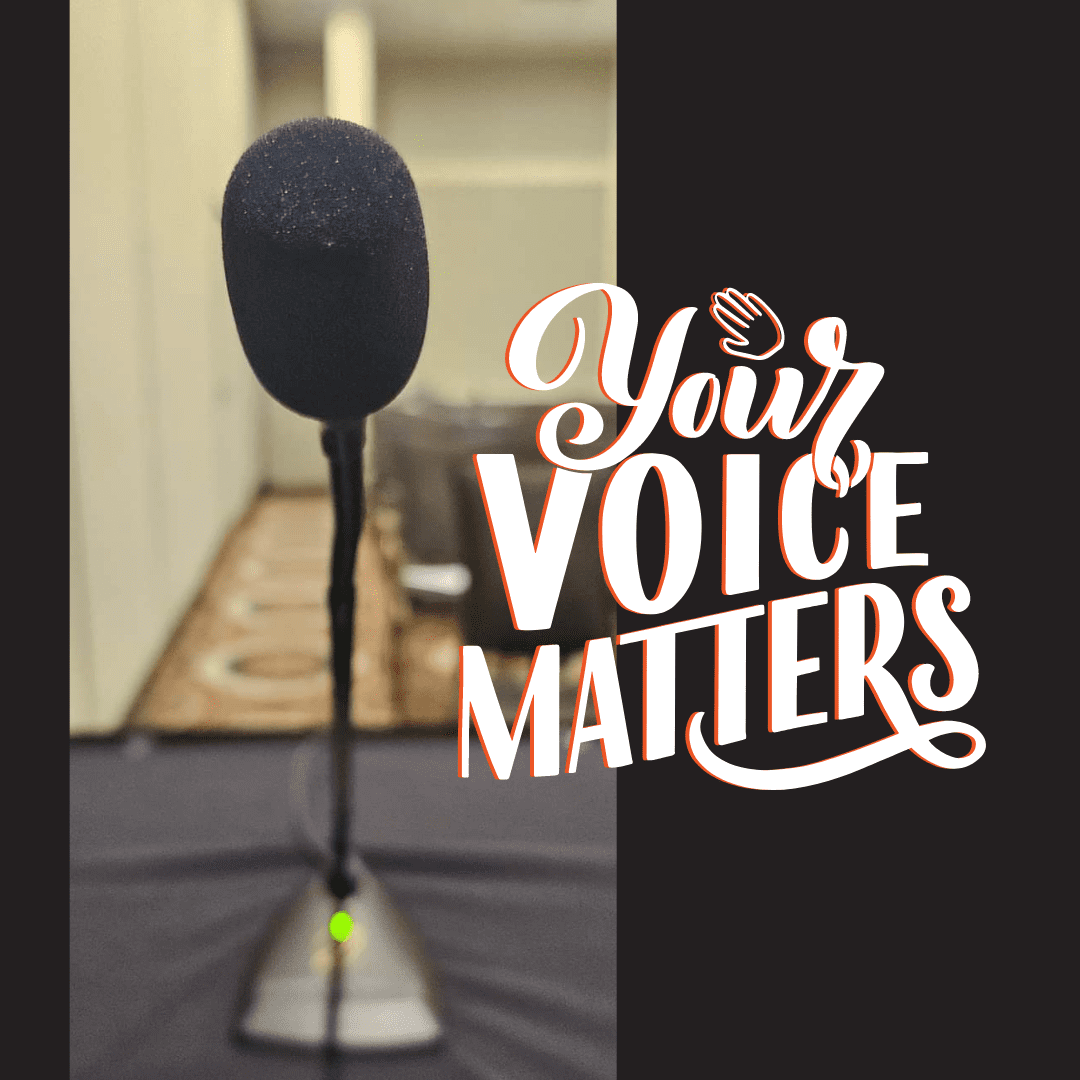 Picture of a microphone on a table in front of a row of chairs with the words, "Your Voice Matters"